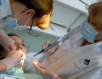 Kenenkään hampaat eivät jää YTHS:ssä keväälläkään hoitamatta. Opiskelija Anni Valovirran hampaiden kimpussa hammaslääkäri Marika Pihlaja (selin) ja hammashoitaja Marja-Liisa Kilpinen. Kuva: Laura Koivisto