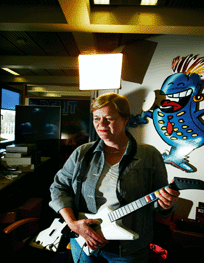 Tuija Lindén on hurahtanut Guitar Hero -kitaransoittopeliin. Kuva: Teemu Kuusimurto.