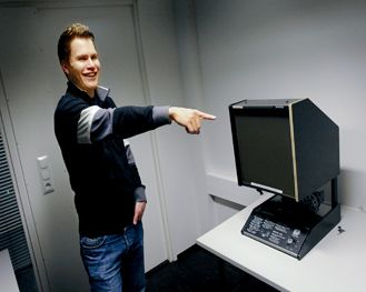 Mikrofilmin lukulaitteen antiikkinen olemus naurattaa teekkaria. Kuva: Timo Marttila
